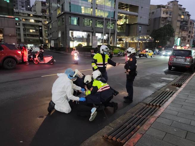 4名员警与救护人员到场，将持刀女子制伏后强制送医。(林郁平摄)