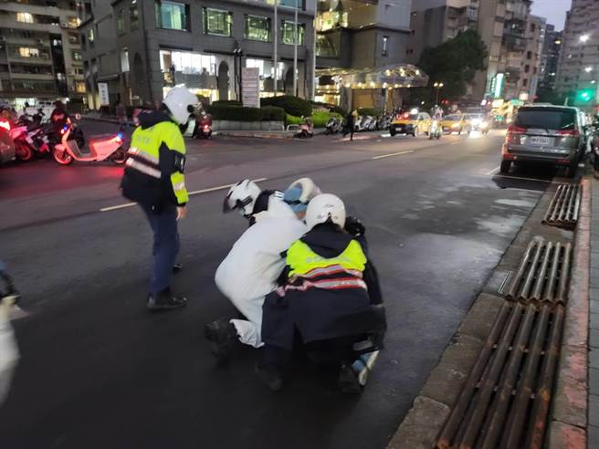 4名员警与救护人员到场，将持刀女子制伏后强制送医。(林郁平摄)