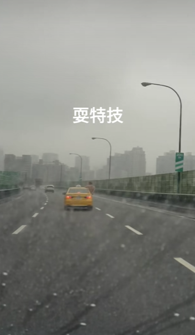 一名网友在国道3号南下，靠近新店交流道处发现前方计程车的车窗内，钻出一名打赤膊男子「坐在车窗」，身体探出来不断比手画脚、疑似还叫嚣。（翻摄自脸书「爆料公社」）