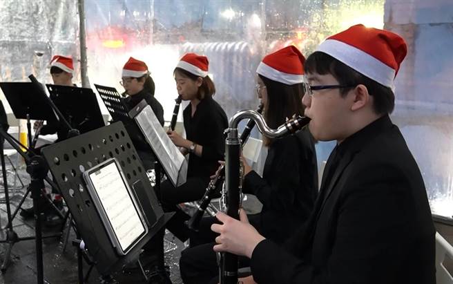 耶誕節即將到來，台北大學今舉行聖誕點燈活動，點亮校門口近9公尺高的巨型聖誕樹，並邀請北大管樂團在現場演奏7首聖誕樂曲，營造濃厚的耶誕氣氛。（台北大學提供）
