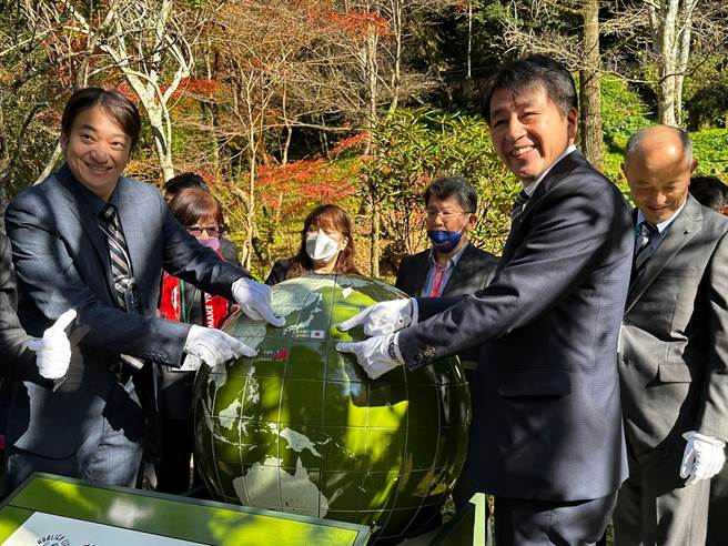 日本高千穗町与花莲市缔结姐妹市满3周年，日方打造一座造型为地球仪的纪念碑，陈设在知名景点高千穗峡内，花莲市长魏嘉贤（左）与町长甲斐宗之（右）一同替其揭幕。（花莲市公所提供／罗亦晽花莲传真）