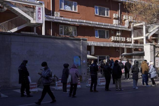 北京各家醫院的發熱門診都排起長長的隊伍，防疫措施突然放鬆讓許多民眾發慌。（圖／美聯社）
