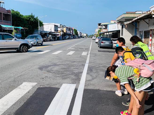 推动交通安全教育，台东信义国小学童向来往车辆鞠躬行礼。（民眾提供）