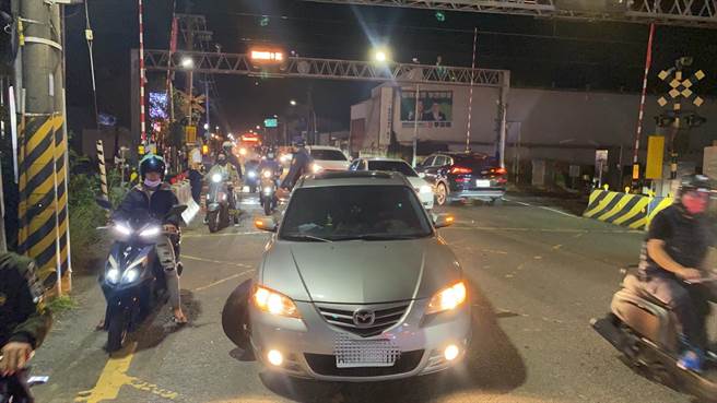 柳营分驻所警力到场后，与多位民眾在列车抵达前，合力将车子推离开平交道，避免事故发生。（读者提供／张毓翎台南传真）