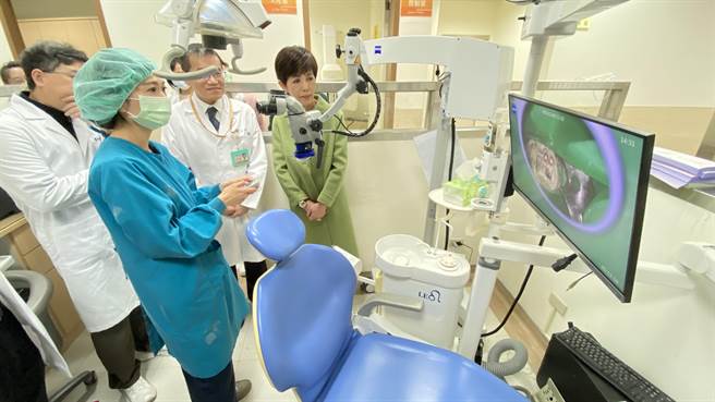 牙科医师示范操作李能缘(右)捐赠的百万级牙科手术显微镜，可放大到肉眼的25倍甚至更高倍率。(于家麒摄)