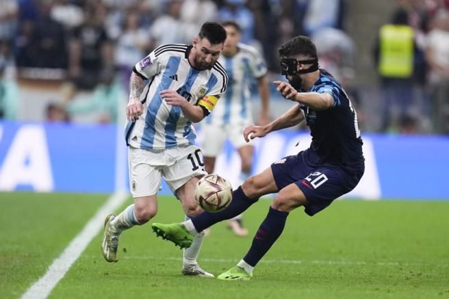 阿根廷前锋梅西(左)带球成功突破克罗埃西亚防守。（美联社）
