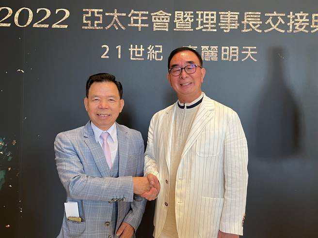 丽明营造董事长吴春山(右)接任亚太经营家协会理事长，与卸任理事长陈阿南(左)握手合影。(林欣仪摄)