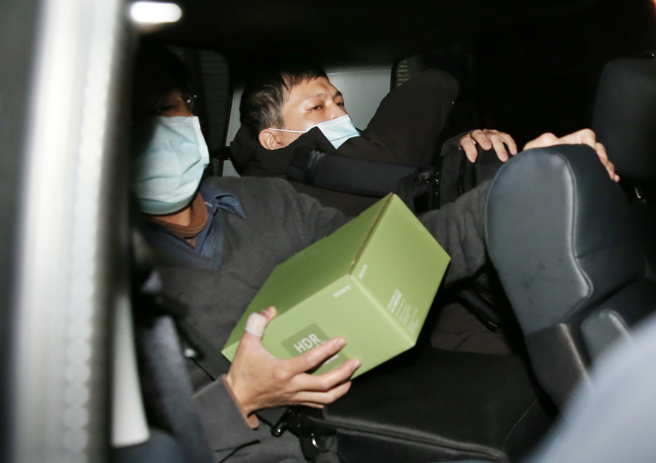 检调搜新竹市长当选人高虹安的立法院委员办公室后，带走办公室主任陈奂宇（右）及一盒资料。（姚志平摄）