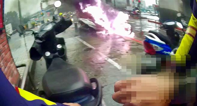 员警发现路边机车起火燃烧，马上徒手将一旁的机车搬移，防止火势延烧。（翻摄照片／林郁平台北传真）