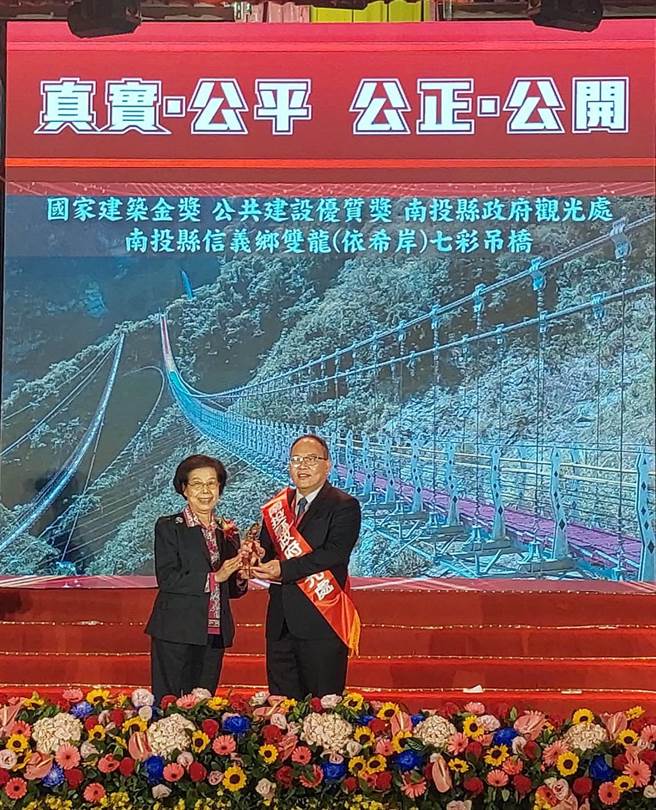 信义乡双龙瀑布七彩吊桥，荣获国家建筑金奖，由南投县观光处长陈志贤（右）代表受奖。（南投县政府提供／廖志晃南投传真）