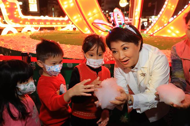 台中市长卢秀燕16日晚间点亮「心花朵朵」耶诞树，宣告中市耶诞嘉年华开幕，卢秀燕与现场小朋友分享雪花之乐。（陈淑芬摄）