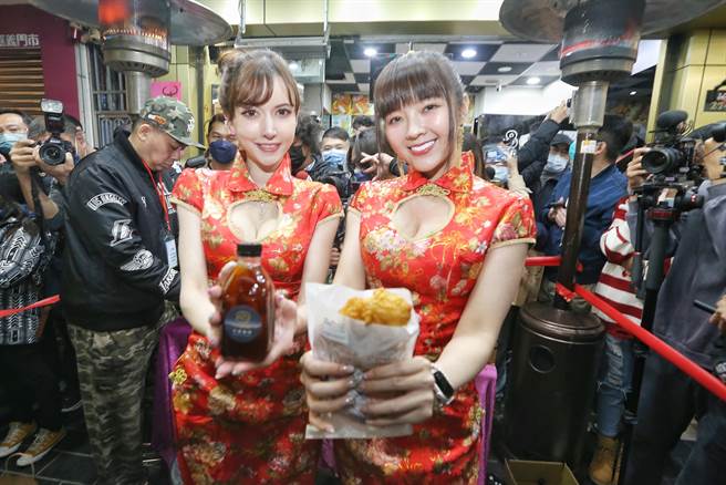 嘉义市第11届无党籍准市议员「顏色不分蓝绿支持性专区顏色田慎节」（右）17日举办「鸡排谢票大会」，并请来「混血女神」泷泽萝拉（左）陪同，两人一同穿着嫣红旗袍及黑丝，尽显姣好身材的发放鸡排谢票。（杜宜谙摄）