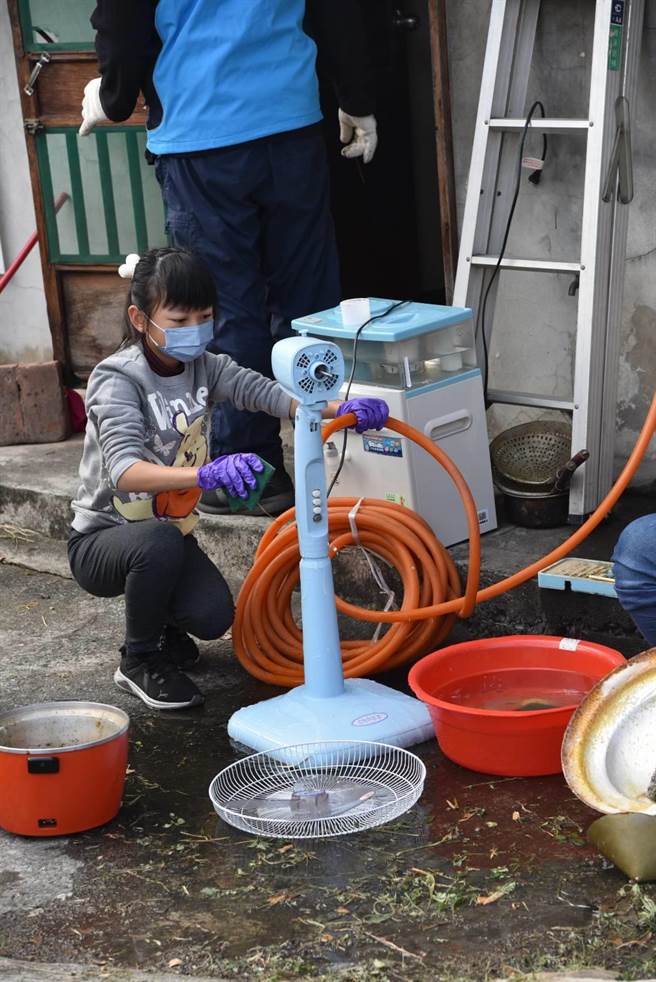 小朋友在10幾度的低溫裡，仔細清洗黃爺爺的電扇。(員林青工提供／吳建輝彰化傳真)