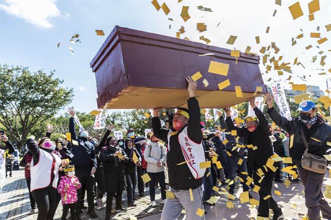 反新竹縣立生命園區自救會在縣府廣場抬棺撒冥紙抗議。（羅浚濱攝）