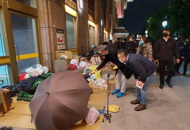 台北市社會局與衛福部長薛瑞元等人在17日晚間赴艋舺公園、萬華避寒所及台北車站為街友致贈暖暖包與防疫口罩，勸導入住避寒所。（社會局提供）