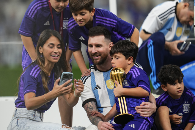 率領阿根廷拿下2022卡達世界盃冠軍後，梅西（中）和家人合照留念。（美聯社）