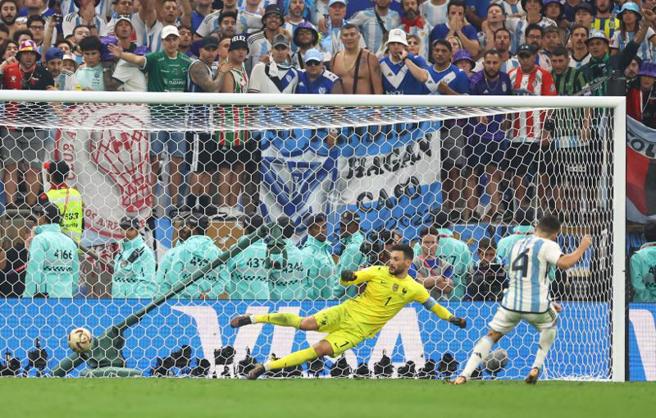PK大战第4点，后踢的阿根廷蒙提尔（右）让法国门将洛里斯扑错方向，轻鬆射入球门左侧，助阿根廷4比2拿下胜利与世界盃冠军。（路透）