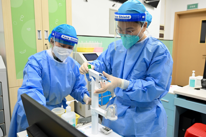 大陆疫情升温，医疗量能紧绷，不少医护被迫带病工作。（中新社）