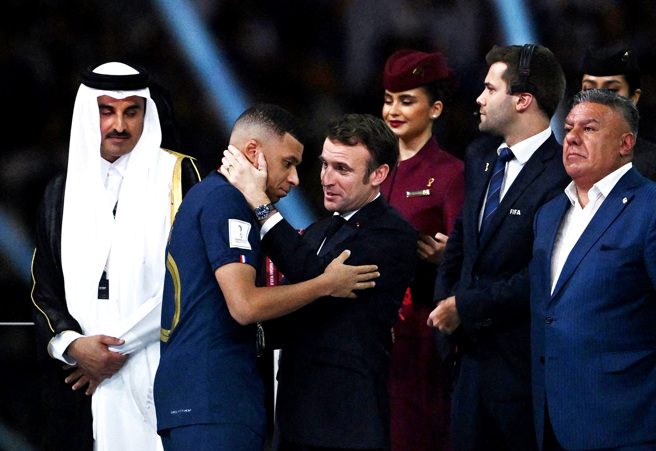 法国队18日在卡达世界杯冠军战中败给阿根廷，法国总统马克宏（Emmanuel Macron）在颁奖仪式上安慰法国前锋姆巴佩（Kylian Mbappe）。（图／路透社）