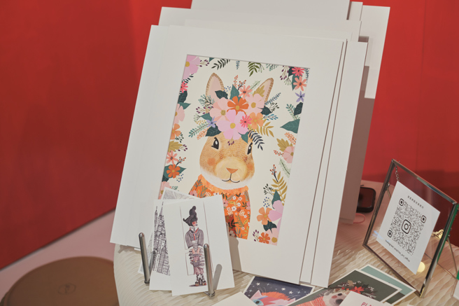 现场展出的作品及明信片。（主办单位提供）