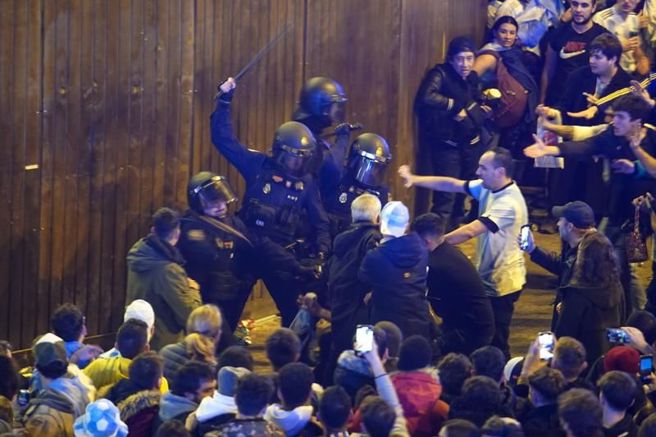 西班牙马德里警方持棍驱离阿根廷球迷。（美联社）
