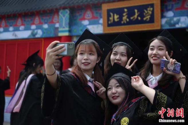 北京大學2021屆本科畢業生在校名前拍照留念。（北京大學）