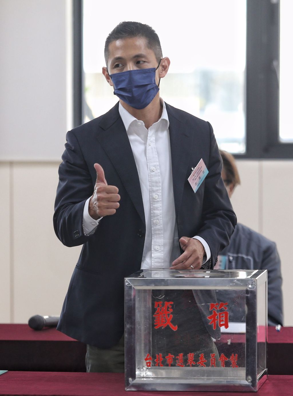 民進黨台北市第三選區立委補選參選人吳怡農（中）20日前往號次抽籤，抽到1號時，吳怡農也順勢比出大拇指。（杜宜諳攝）