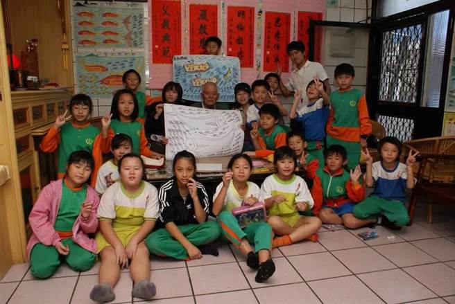 育英国小主任刘文正用爷爷（中）的画作，引导孩童重视海洋生态永续的发展。（育英国小主任刘文正提供／吴佩蓉宜兰传真）