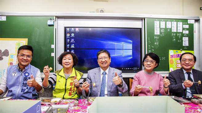 县长杨文科（中）品尝石斑鱼，指目前全国还有9个县市学生还未吃到石斑鱼，新竹县学生12月底能吃到第3次，真的很幸福。（罗浚滨摄）