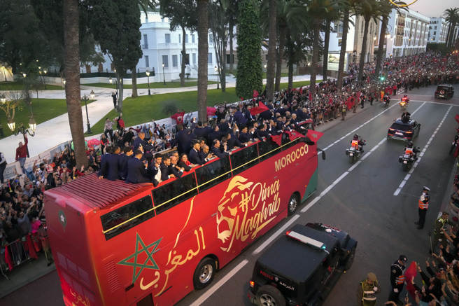 摩洛哥足球队搭乘双层巴士游行，接受球迷欢呼。（美联社）