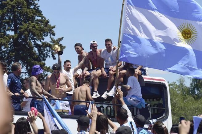 梅西(白衣者)在阿根廷街头游行高举冠军盃。（美联社）
