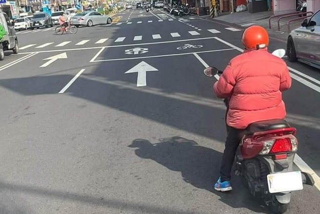 网友发现路上一名机车女骑士停等红灯不是「躲太阳」，而是「躲阴影」，就是为了多晒点太阳，类似画面与夏天时，机车族躲在阴影下遮阳的画面恰恰相反。（翻摄自脸书「爆废公社」）
