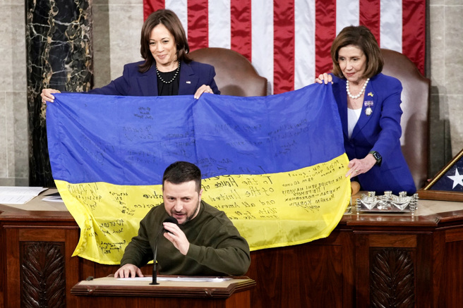 乌克兰总统泽伦斯基（Volodymyr Zelenskyy）21日赠予美国国会一面有着乌克兰士兵签名的乌克兰国旗。（图／美联社）