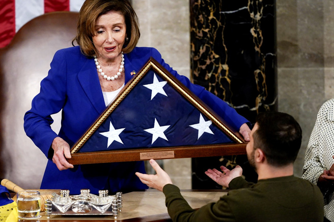 乌克兰总统泽伦斯基（Volodymyr Zelenskyy）21日赠予美国国会一面有着乌克兰士兵签名的乌克兰国旗，裴洛西则回赠一面折迭的美国国旗。（图／美联社）