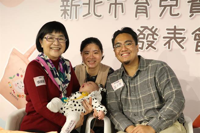 初为人父的王子军（右）和太太分享使用新北市育儿资讯网和育儿育儿宝贝袋的经验，怀中3个月大的宝宝刚好搭了一个哈欠，左为社会局长张锦丽。（陈慰慈摄）