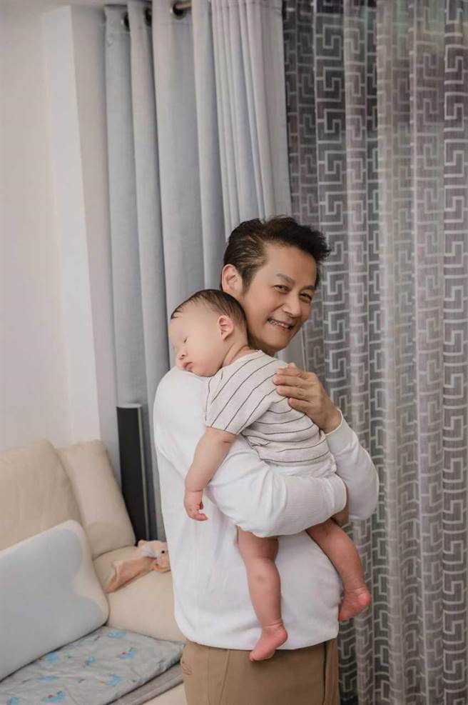  徐乃麟哄孙有一套，孙子在他怀中放心沉睡。（艾迪升传播提供）