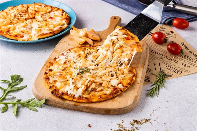 铺满鲑鱼牵丝出金黄起司瀑布的「美威鲑鱼海鲜披萨」，层次相当丰富。（美威鲑鱼提供）