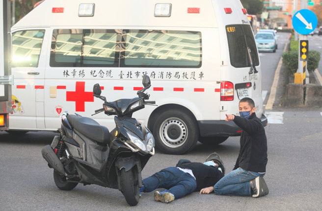 吴怡农(右)跑行程时在内湖遇见车祸事故，立即下车看顾伤者，直到救护车到场接手才离开。（张铠乙摄）