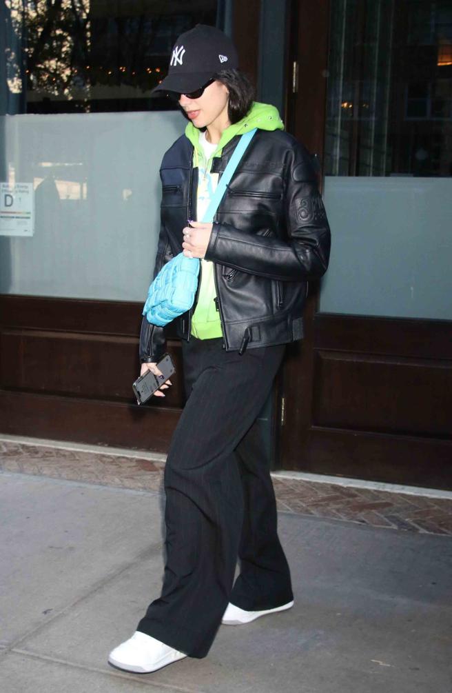 杜娃黎波（Dua Lipa）皮衣搭綠色帽踢帥氣演繹Bottega Veneta 抓皺 foulard Cassette 肩背包。（Bottega Veneta 提供）