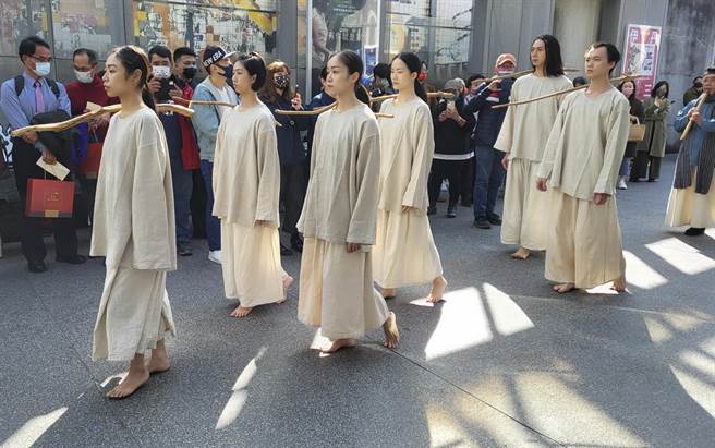 《海之岸》参与共创的艺术家在首映会穿着演出服装，右肩放着漂流木，象徵白鹭鸶啣木筑巢，引领观眾入场。（黄子明摄）