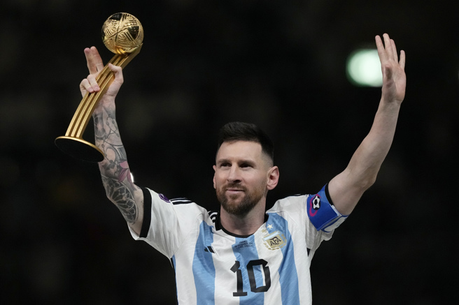梅西作为阿根廷队长高举大力神盃，庆祝夺下世界盃冠军。(美联社)