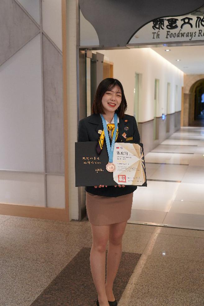 旅馆接待竞赛项目是台湾首次参赛的职类，国际观光系四年级刘玫均仪态大方，有条不吝完成赛程，从日本、义大利、法国、西班牙等16国中，获取优胜，显现大将之风。 (国立高雄餐旅大学提供) 