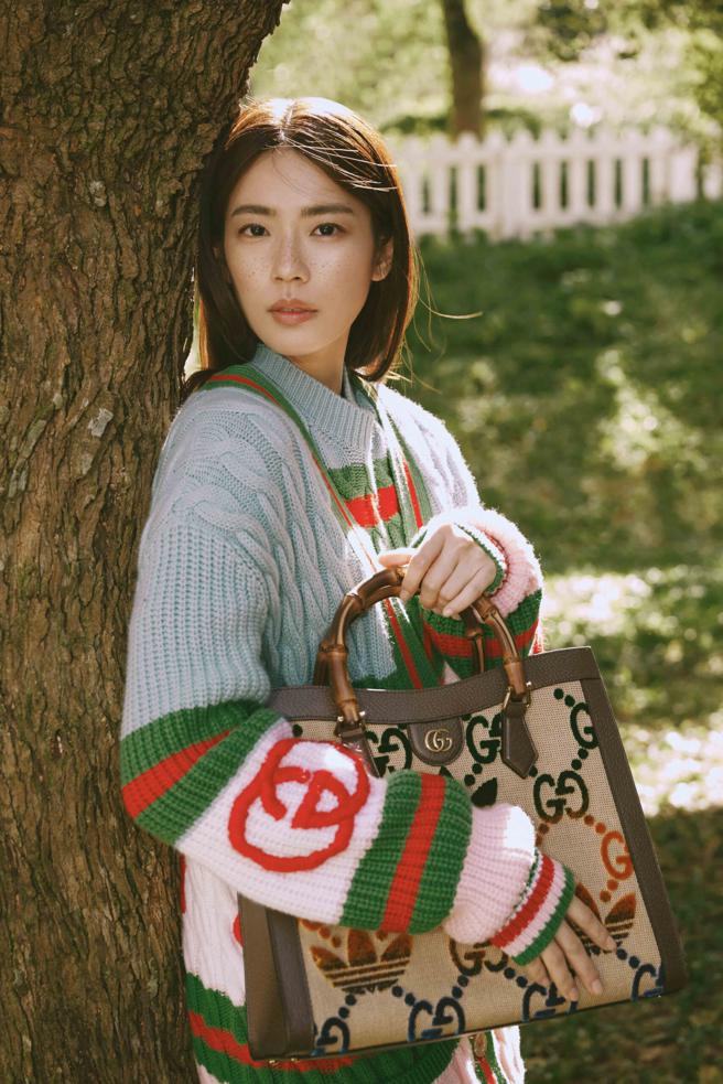林思宇着adidas x Gucci联名第二弹针织套装，搭配双Logo的竹节包徜徉于冬日阳光下。（Gucci提供）
