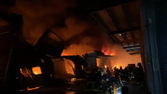 新北八里大火連燒5間工廠 爆炸聲不斷 1消防員遭灼傷送醫