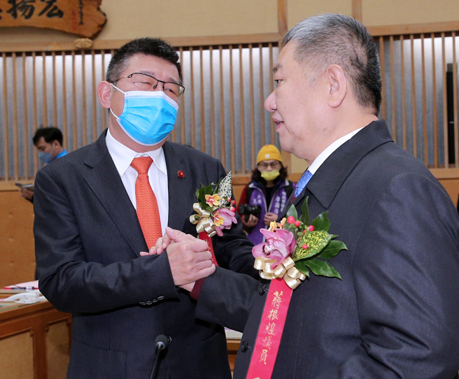 新北市議會第4屆議員25日報到就職，正副議長熱門人選蔣根煌（右）、陳鴻源（左）兩人在議場內握手致意。（黃世麒攝）