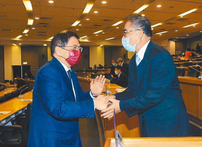 台灣大學校長管中閔（左）24日主持任內最後一次校務會議。圖為管中閔向即將接任校長的陳文章（右）握手致意。（中央社）