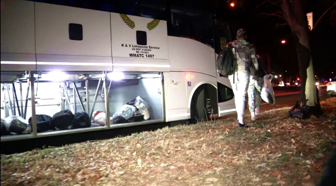 24日耶诞夜寒风中，3车中南美洲移民被丢包在美国副总统贺锦丽华府官邸外。画面为华府当地机构安排移民搭上另一辆交通车前往教会。（图／美联社）