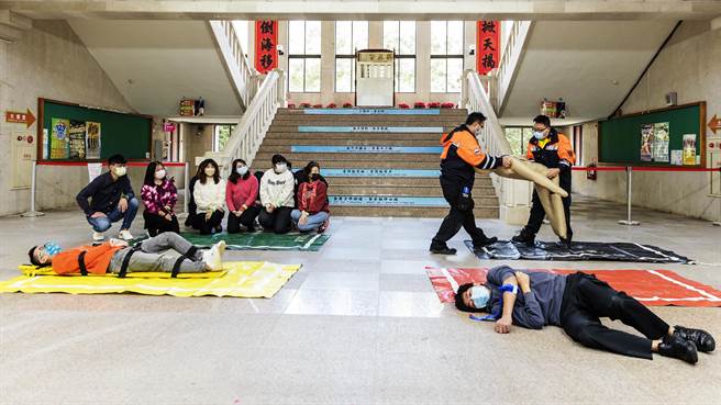 新竹县消防局演练大量伤病患检伤分类，伤势区分为红、黄、绿、黑4种顏色，救护人员将明显死亡者抬到黑区。（罗浚滨摄）