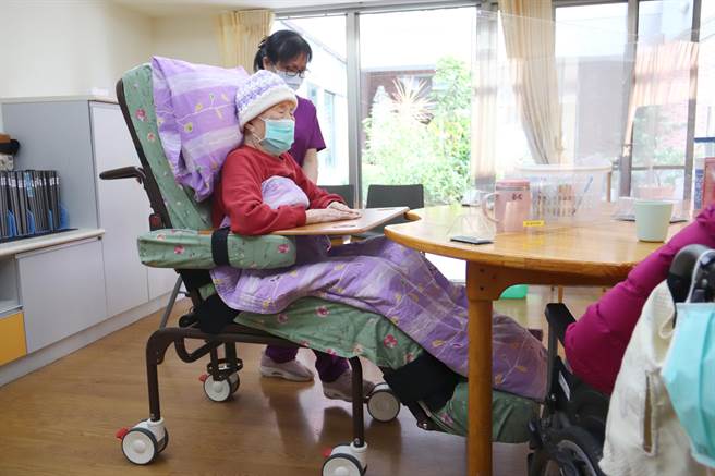 照服员操作将智能「3合1移位床」变成轮椅。（庄哲权摄）