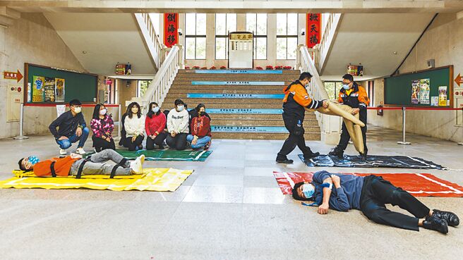新竹縣消防局演練大量傷病患檢傷分類，傷勢區分為紅、黃、綠、黑4種顏色，救護人員將明顯死亡者抬到黑區。（羅浚濱攝）